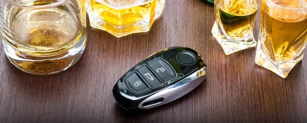 Car key and whiskey glasses symbolizing Stokes County DWI case dismissal.