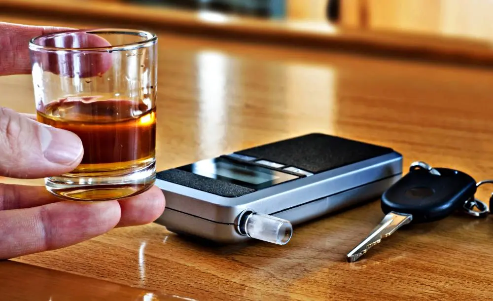 Police officer performing roadside breathalyzer test for alcohol detection.