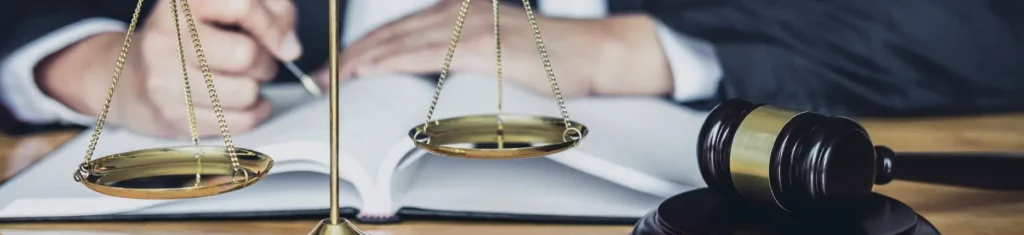 Gavel and scales of justice on desk symbolizing court non-compliance hearing and legal authority.
