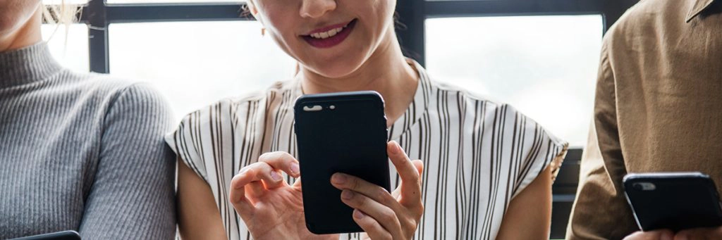 Woman smiling while using her smartphone, highlighting concerns about online privacy in the digital age.