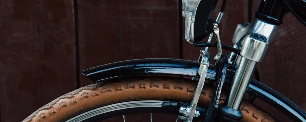 Close-up of a bicycle wheel and frame against a wooden background, illustrating the topic of DUI on a bicycle in NC.