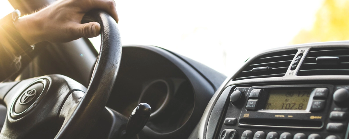 Close-up of a man’s hand on the steering wheel of a Toyota, symbolizing restored driving privileges and the financial journey tied to DUI cost.