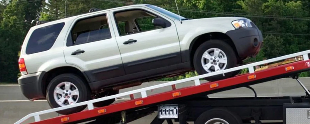 SUV being towed onto a flatbed truck, representing a common DUI cost related to vehicle impoundment.