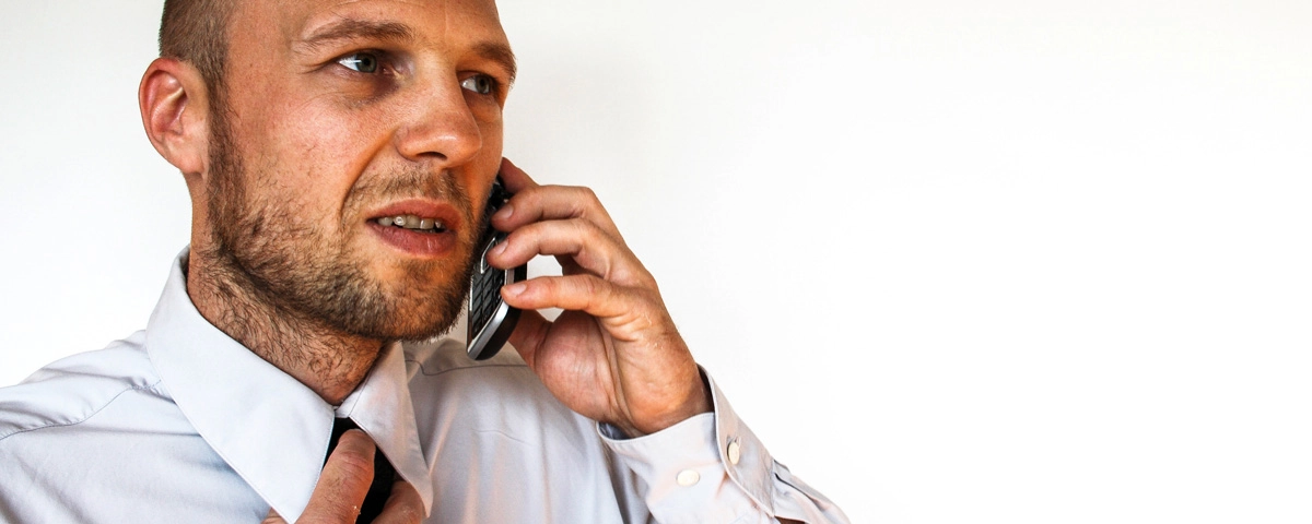 Concerned man on phone call adjusting tie, symbolizing communication issues in a client-attorney relationship.