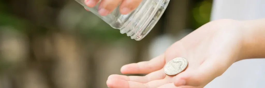 Hand holding a coin with an empty jar above, symbolizing a motion to decrease child support.