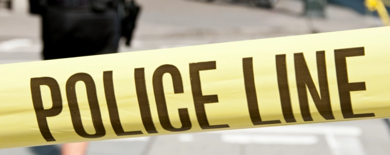 Close-up of yellow police line tape blocking off a crime scene area.