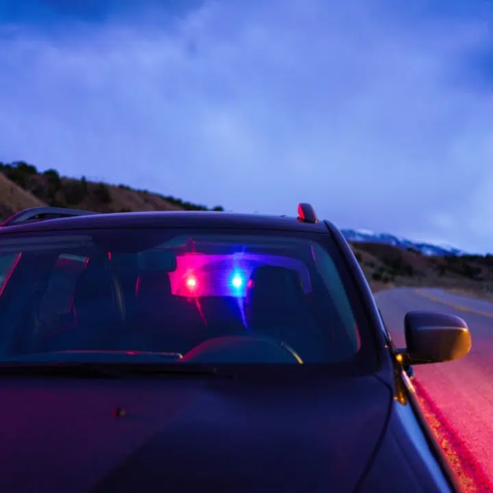 Police lights reflected in car windshield indicating signs of impaired driving