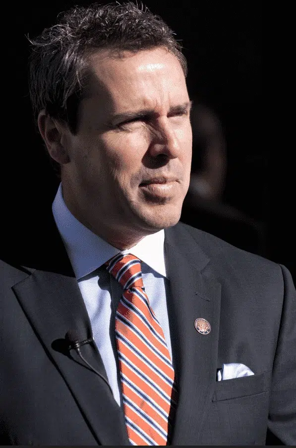Mark Walker wearing a suit and striped tie, standing outdoors.