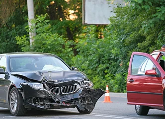 Damaged cars after a traffic collision on a busy city street.