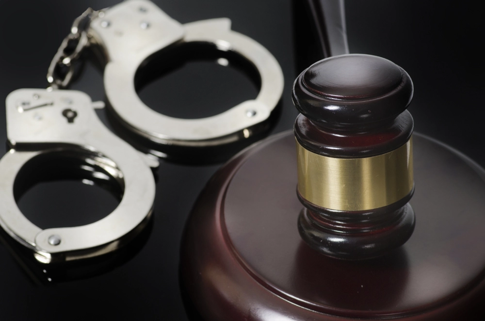 Judge’s gavel and handcuffs symbolizing law, justice, and criminal court.