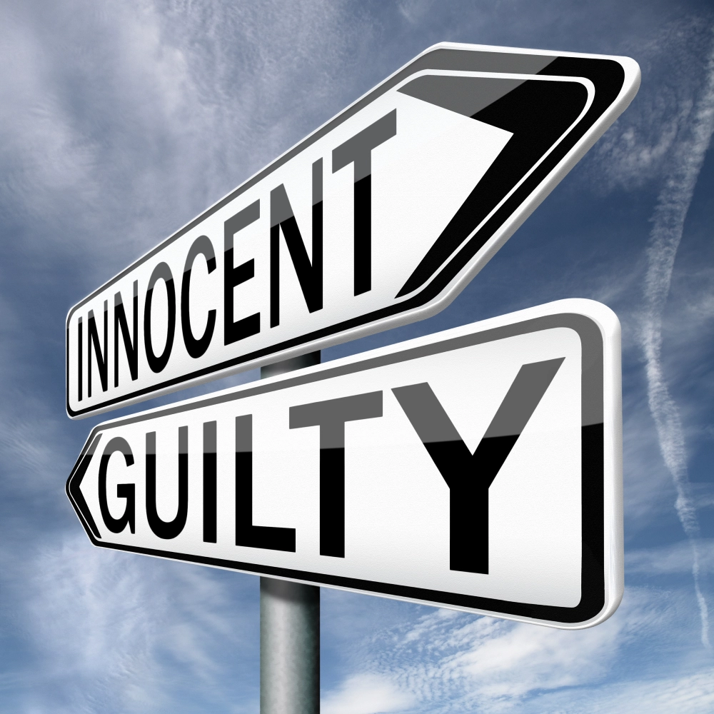 Justice concept signpost showing Innocent and Guilty directions under blue sky.