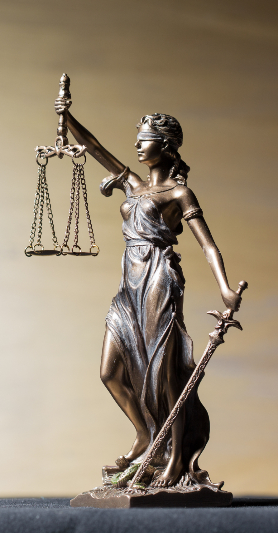 Bronze Lady Justice statue with scales and sword, symbolizing law and fairness.